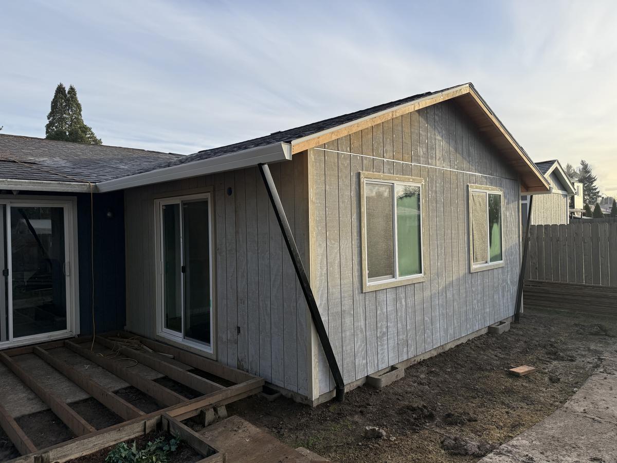 Portland home addition finished with gray vertical siding and new windows