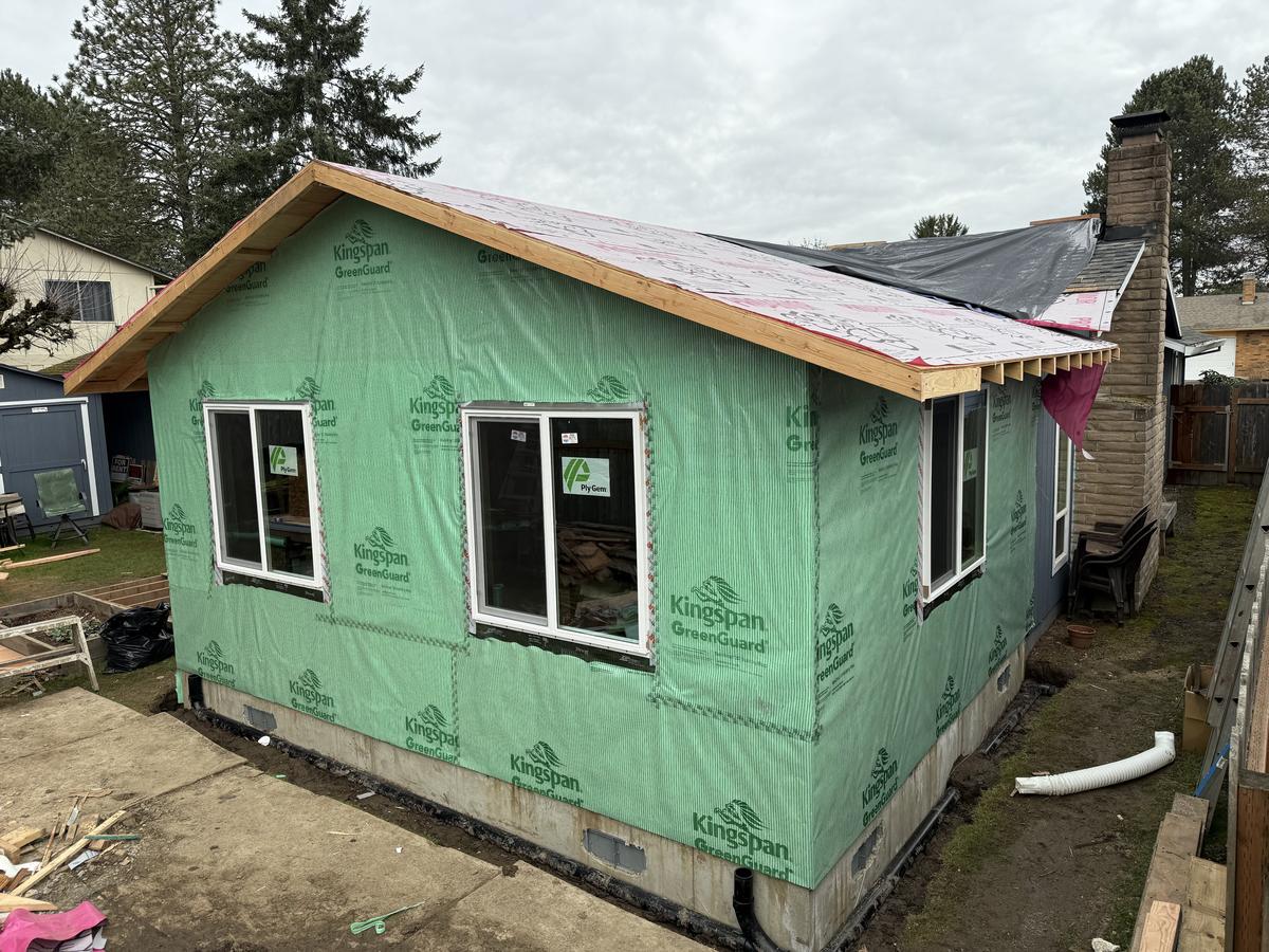 Framed and sheathed Portland home addition wrapped in house wrap with new windows