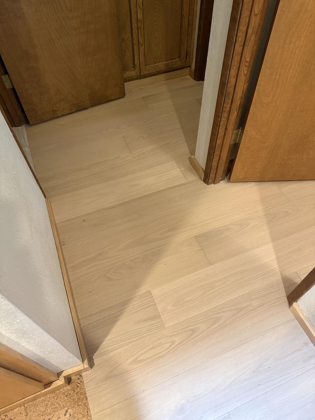 Hallway with new light wood-tone plank flooring in a Portland-area home