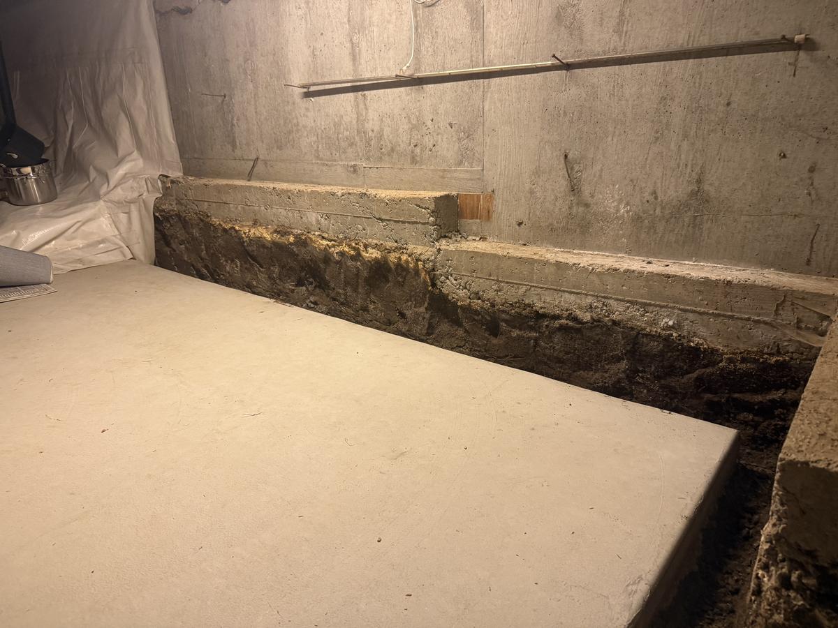 Basement repair by our crew: new concrete slab and curb against a basement wall in the Portland area