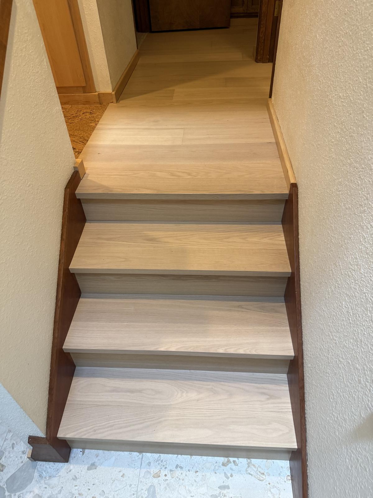 New light wood-tone stair treads and landing flooring in a Portland-area home