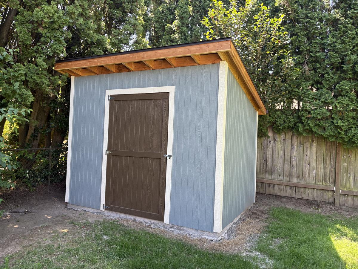 Custom backyard shed with brown door and wood fascia in Portland, OR