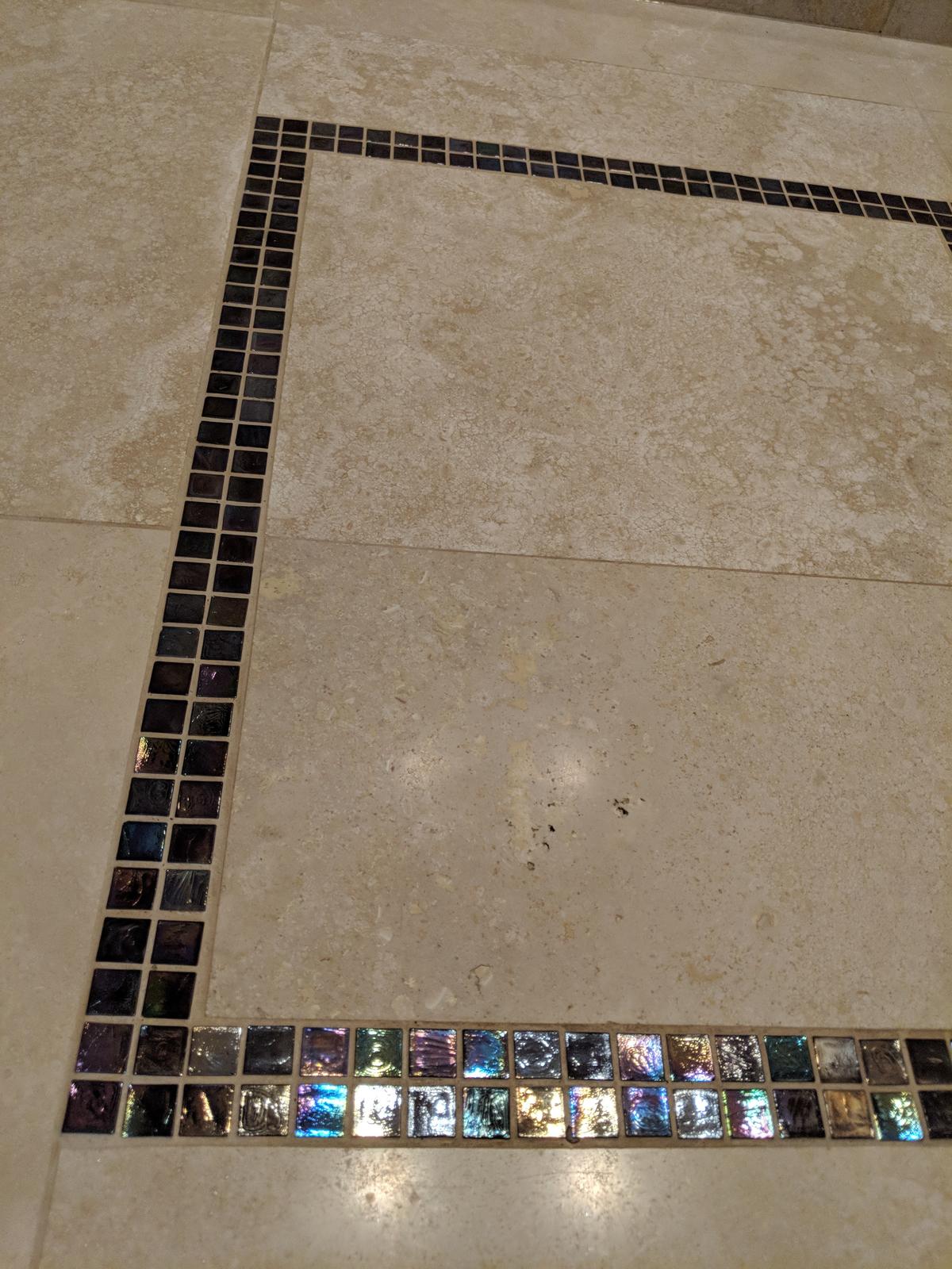 Close-up of a glass mosaic tile border in a Portland bathroom tile floor