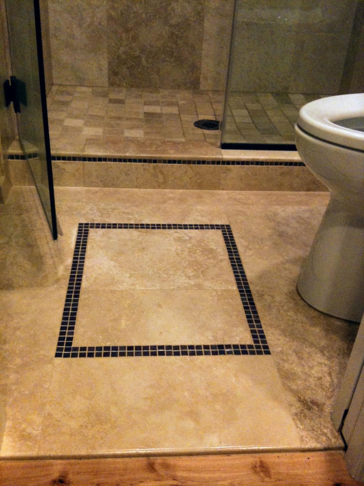 Portland bathroom remodel with a tile floor inlay and mosaic border beside a glass shower