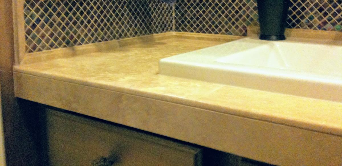 Bathroom vanity with stone-look countertop and mosaic tile backsplash in Portland, OR