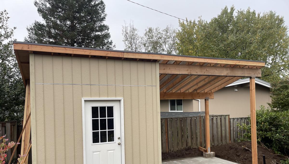 Portland shed with an attached covered lean-to over a paver patio