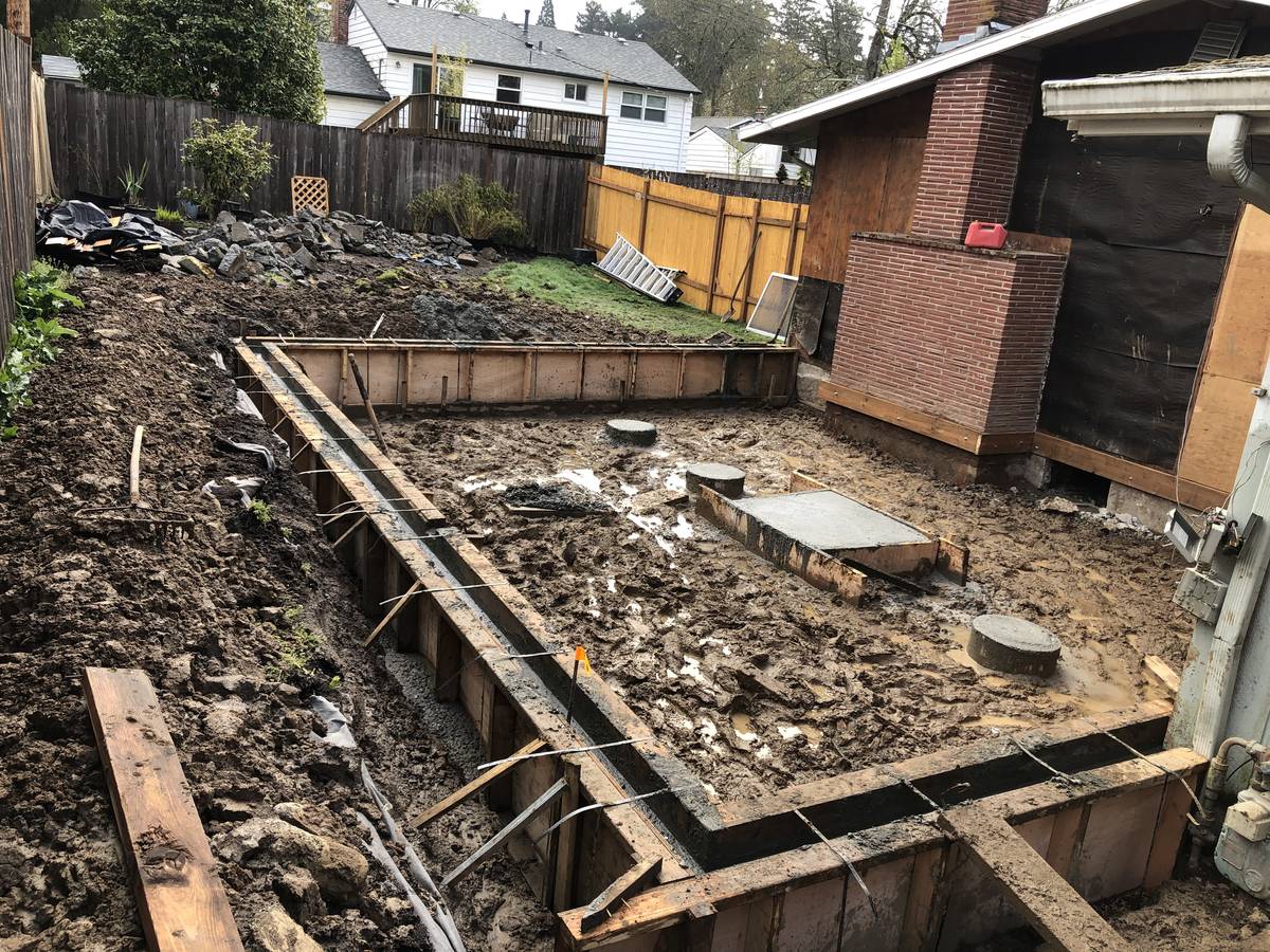 Excavated footprint with footing forms for a Portland house addition