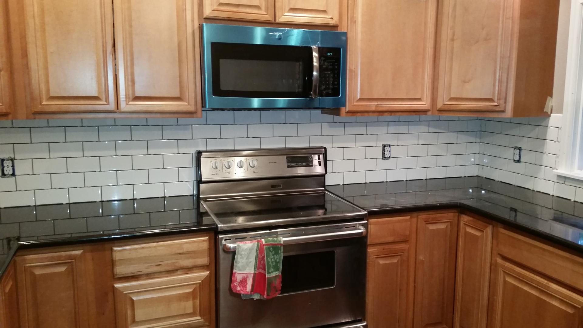 Portland kitchen remodel with wood cabinets, white subway tile backsplash and dark countertops