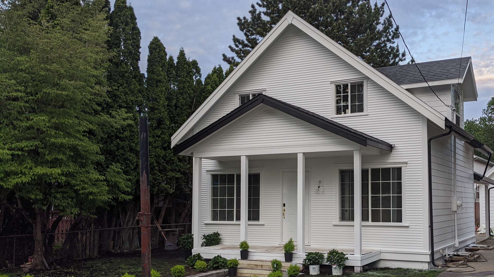 Whole-house remodel with white siding, covered porch and new landscaping